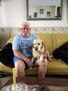 847978 Portret van Jan Evers, met zijn hond zittend op de bank in zijn woning in het Lange Rozendaal te Utrecht.